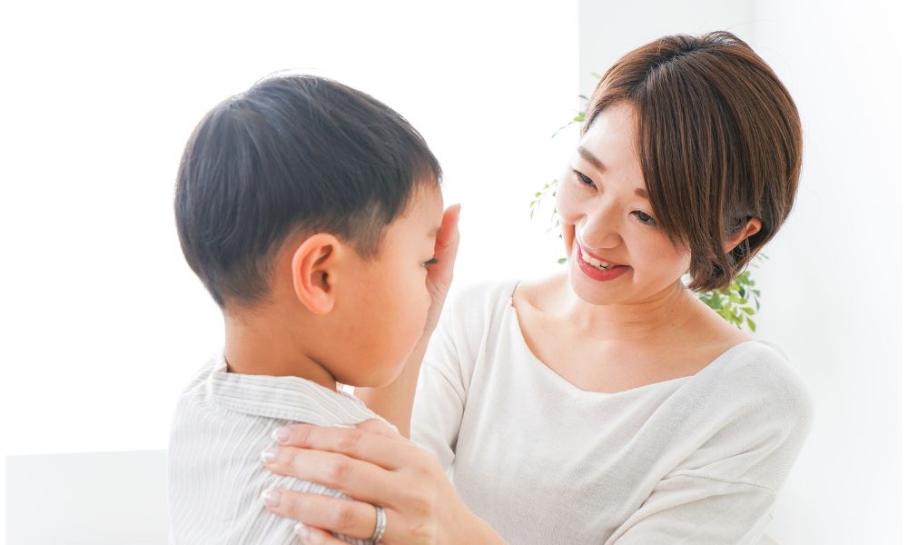 泣いている子を優しくなだめる母親