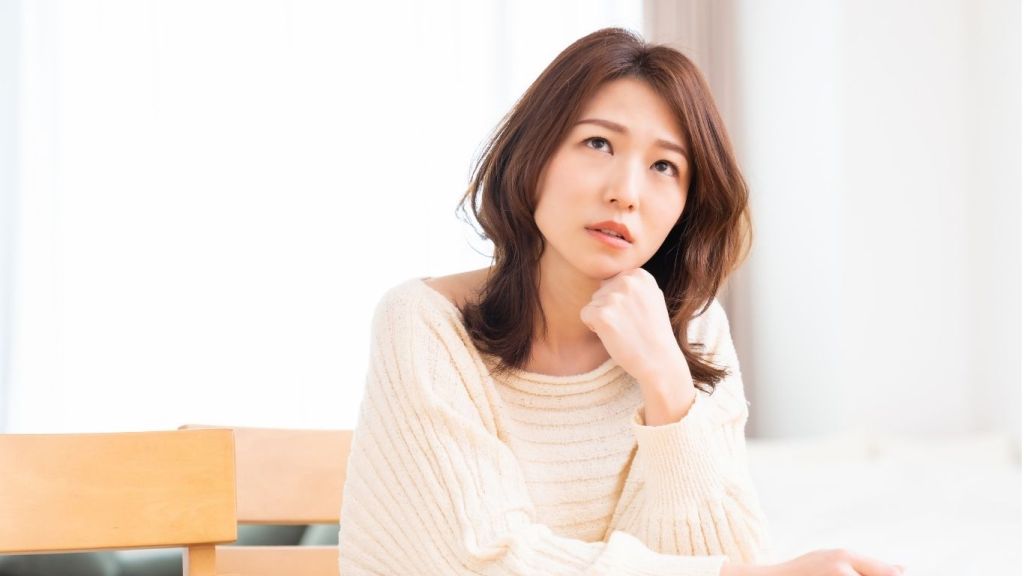 顎に手を当て考える女性