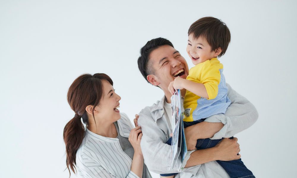 子どもを抱き上げて笑顔で過ごす家族