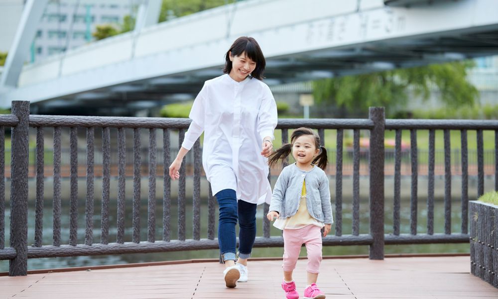 川沿いを散歩する母と娘
