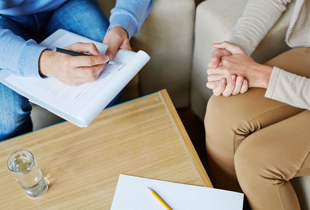 カウンセリングで相談を受け、書類に記入する場面