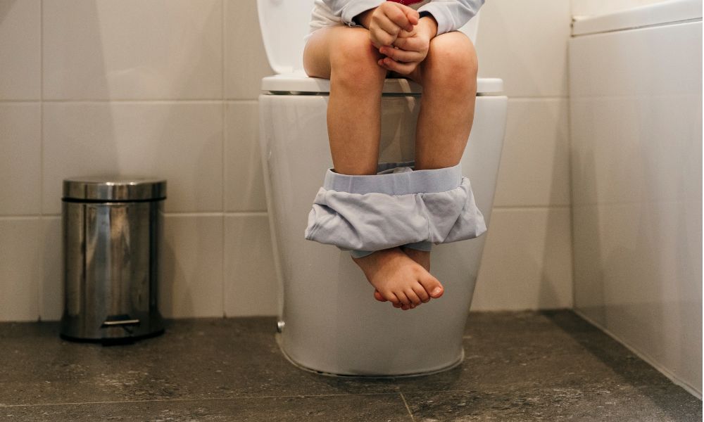 トイレに座っている子どもの足元を写した写真