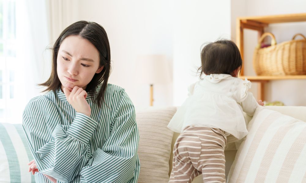 どもの行動を見ながら少し悩む母親の様子
