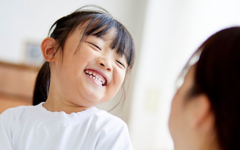 保護者と向き合い、安心した表情で笑う子どもの様子
