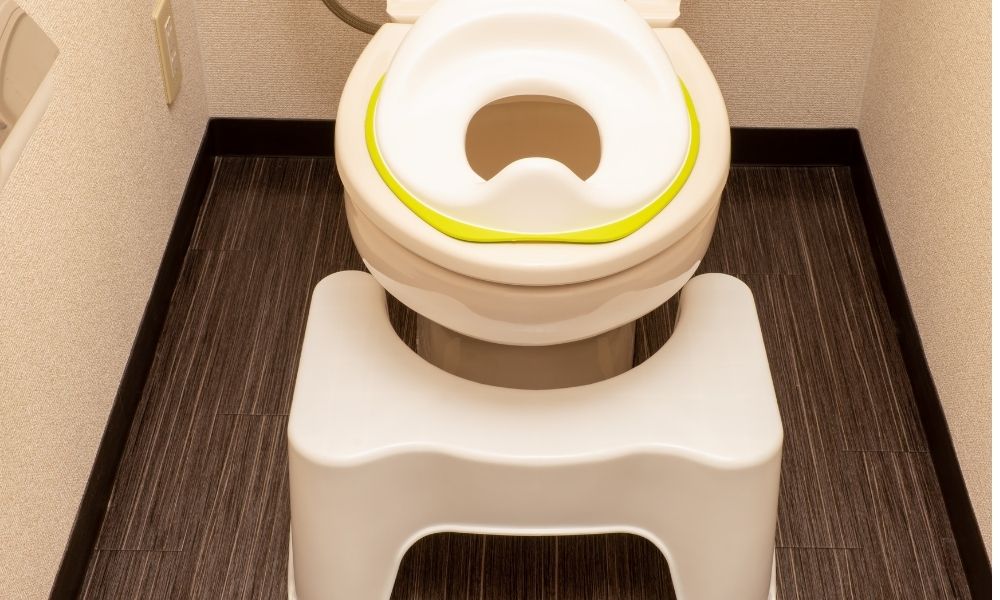 住宅のトイレに、子ども用の補助便座と踏み台が設置されている。