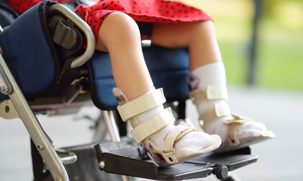 肢体不自由のある子どもが車いすに座り、装具を装着している足元の様子