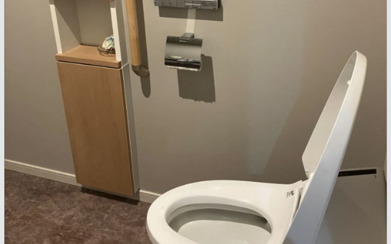 明るすぎないあたたかい照明に調節された、木目調のトイレ空間