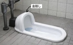 前と同じ和式トイレの画像で、金隠しを示す矢印が記されています