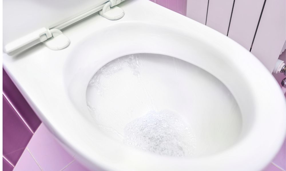 水が流れている洋式トイレの便器の中を上から見た写真。水面に勢いよく水が当たり、水しぶきが上がっている様子